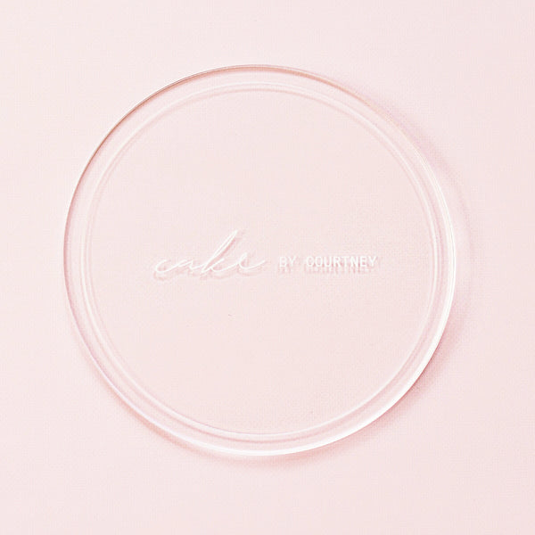 single acrylic disk against a pink backdrop.
